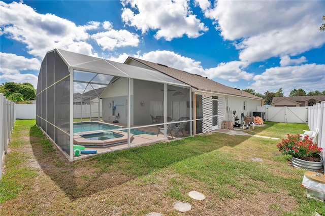 back of property with a fenced backyard, a gate, a patio area, a lawn, and a pool with connected hot tub