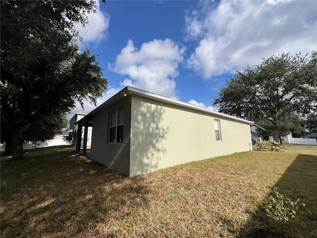 view of home's exterior featuring a lawn and stucco siding