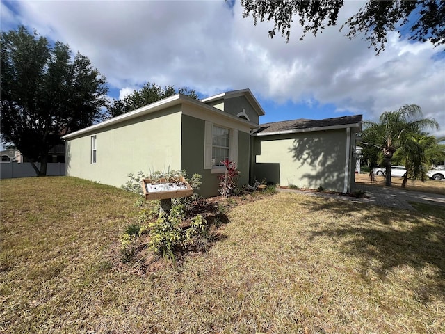 view of property exterior featuring stucco siding and a yard