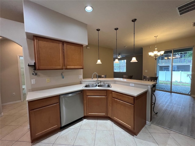 kitchen with visible vents, brown cabinets, dishwasher, a sink, and a peninsula