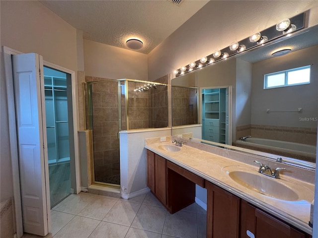 full bathroom featuring a sink, a walk in closet, a shower stall, and a textured ceiling