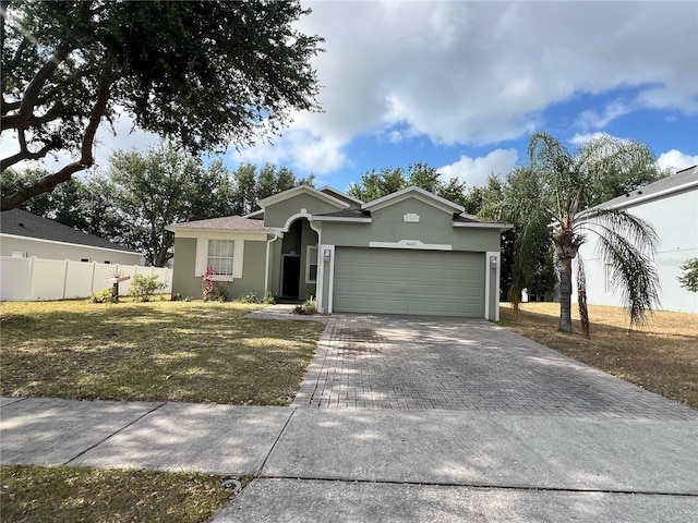 view of front of property with fence, a front yard, decorative driveway, stucco siding, and an attached garage