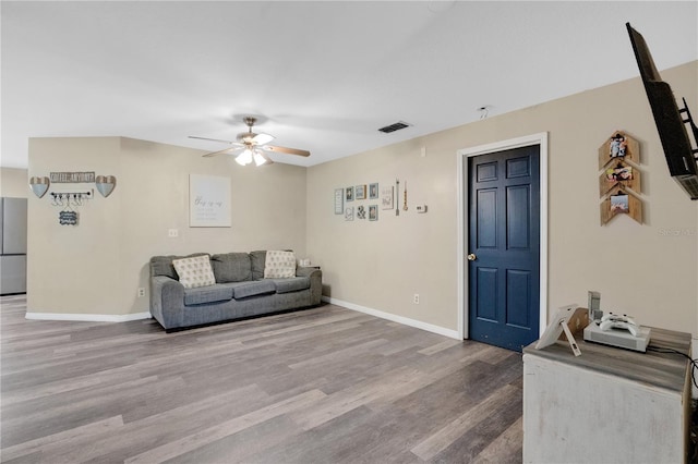 living room featuring visible vents, baseboards, ceiling fan, and wood finished floors