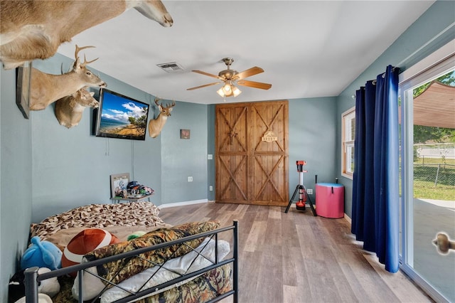 interior space with baseboards, ceiling fan, visible vents, and wood finished floors