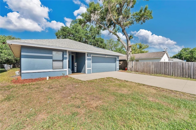 ranch-style home with concrete driveway, fence, a front yard, and a garage