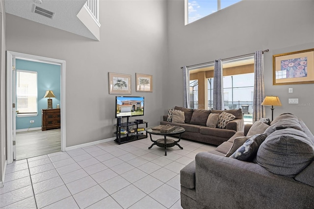 209 Rosso Dr, Davenport, FL 33837 - living area with a high ceiling, light tile patterned floors, healthy amount of natural light, and baseboards