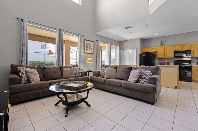 209 Rosso Dr, Davenport, FL 33837 - living area with light tile patterned flooring, a textured ceiling, and a towering ceiling