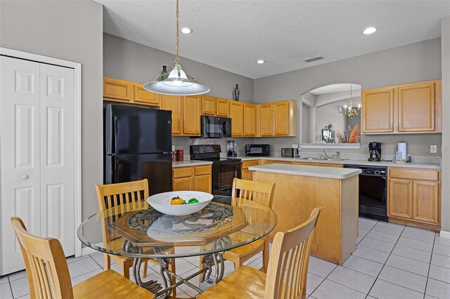 209 Rosso Dr, Davenport, FL 33837 - kitchen with black appliances, a sink, a kitchen island, light countertops, and light tile patterned flooring