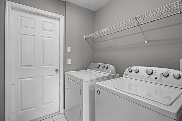 209 Rosso Dr, Davenport, FL 33837 - laundry area with independent washer and dryer, a textured ceiling, and light tile patterned flooring
