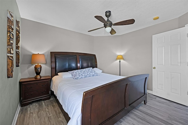 209 Rosso Dr, Davenport, FL 33837 - bedroom with baseboards, wood finished floors, ceiling fan, and a textured ceiling