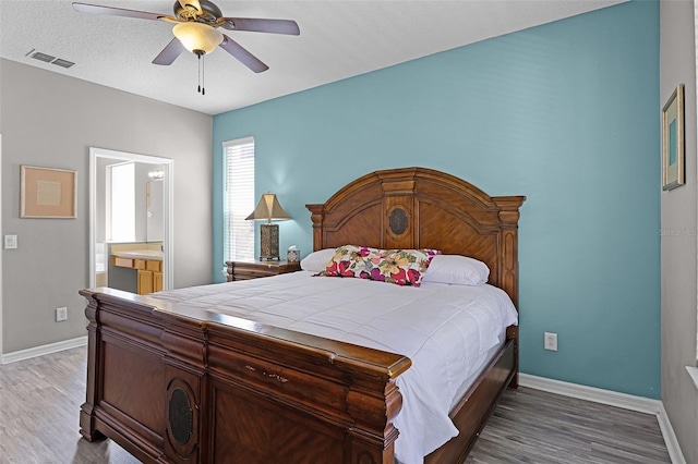 209 Rosso Dr, Davenport, FL 33837 - bedroom with light wood finished floors, baseboards, ceiling fan, and ensuite bathroom