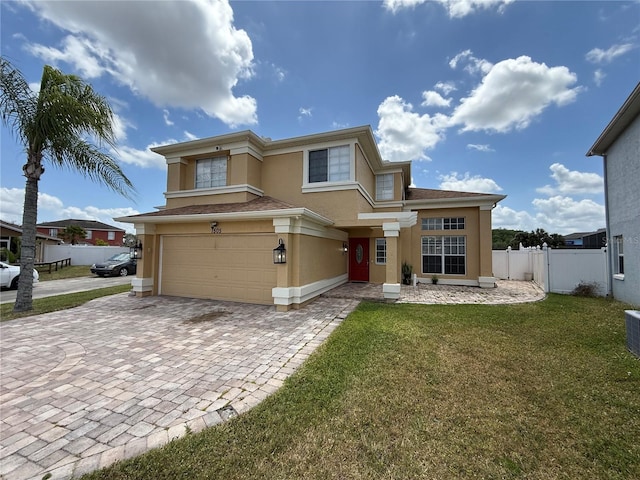 view of front of property featuring a garage, fence, a front yard, decorative driveway, and stucco siding