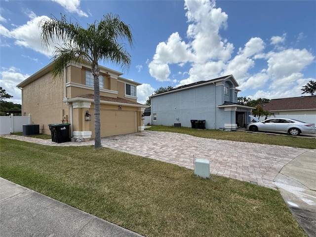view of property exterior with a lawn, decorative driveway, stucco siding, an attached garage, and central air condition unit