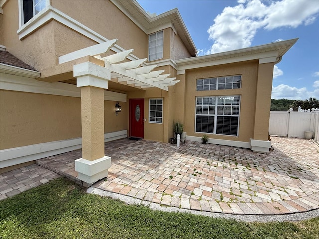exterior space with a patio, fence, a pergola, and stucco siding