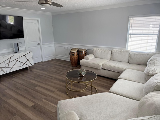 living area with crown molding, dark wood-type flooring, plenty of natural light, and a wainscoted wall