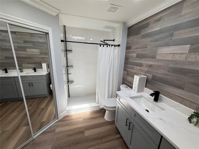 bathroom featuring toilet, a stall shower, visible vents, and vanity