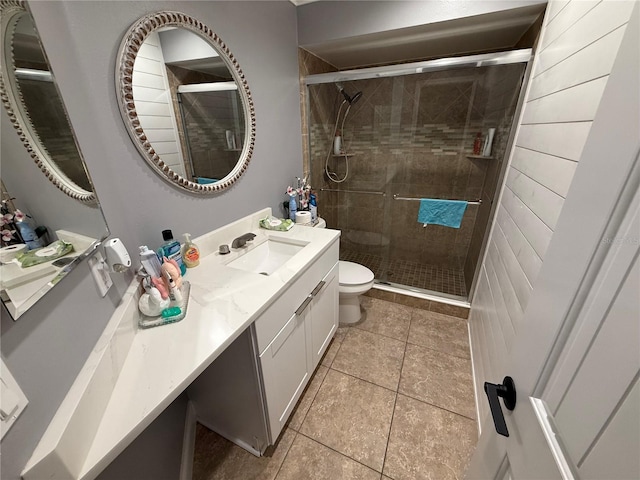 full bath featuring toilet, tile patterned floors, a shower stall, and vanity