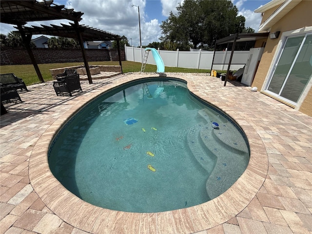 view of pool with a fenced backyard, a water slide, a pergola, and a patio area