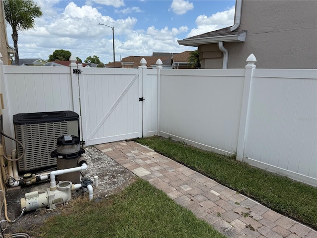 view of yard featuring a gate, fence, and cooling unit