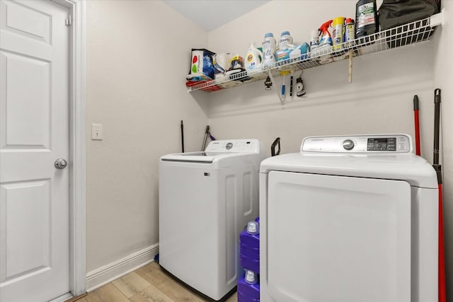 131 Highland Meadows Pl, Davenport, FL 33837 - washroom with washer and clothes dryer, light wood-type flooring, and baseboards