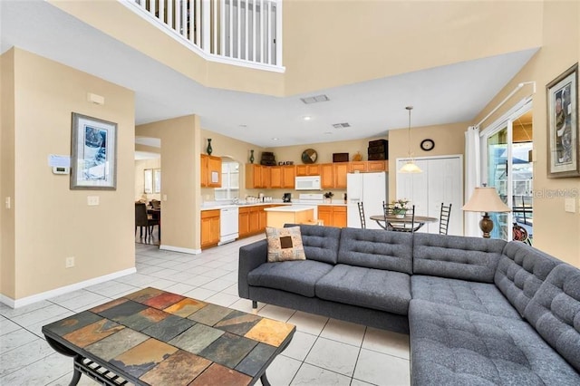 2632 Emerald Island Blvd, Kissimmee, FL 34747 - living area featuring light tile patterned floors, baseboards, a high ceiling, and visible vents