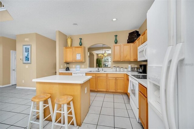 2632 Emerald Island Blvd, Kissimmee, FL 34747 - kitchen with a kitchen breakfast bar, light tile patterned floors, a kitchen island, and white appliances