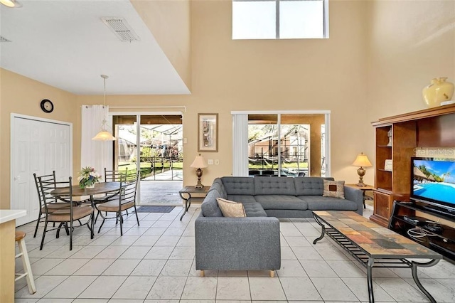 2632 Emerald Island Blvd, Kissimmee, FL 34747 - living room with visible vents, a high ceiling, light tile patterned floors, and a wealth of natural light