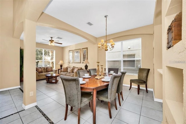 2632 Emerald Island Blvd, Kissimmee, FL 34747 - dining area with visible vents, baseboards, arched walkways, ceiling fan with notable chandelier, and light tile patterned floors