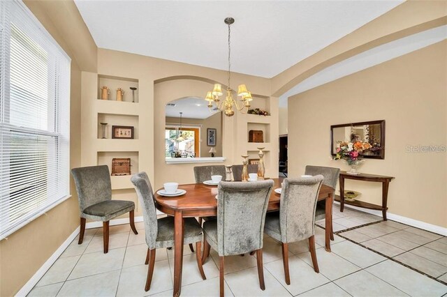 2632 Emerald Island Blvd, Kissimmee, FL 34747 - dining space featuring an inviting chandelier, arched walkways, baseboards, and light tile patterned floors