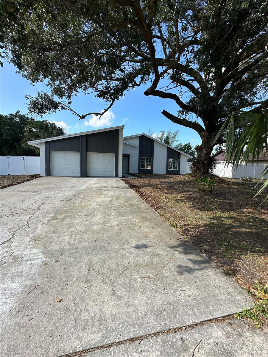 view of front of house with fence and concrete driveway