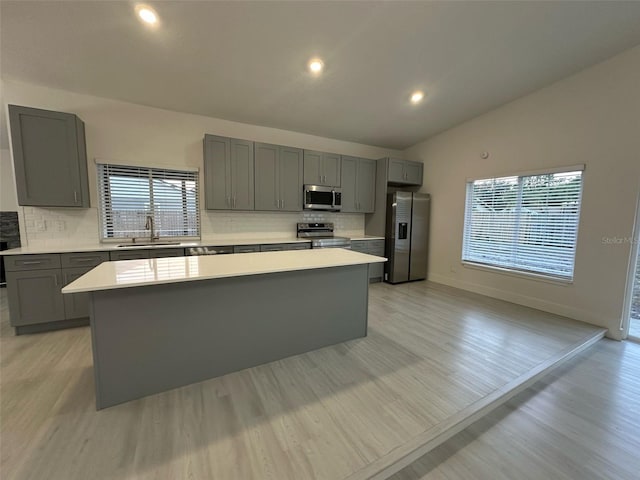 705 Wood Ln, Kissimmee, FL 34759 - kitchen featuring a sink, gray cabinets, light countertops, a kitchen island, and appliances with stainless steel finishes