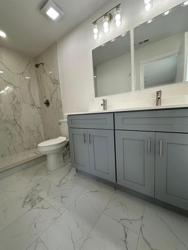 705 Wood Ln, Kissimmee, FL 34759 - bathroom featuring toilet, marble finish floor, a textured ceiling, a marble finish shower, and double vanity