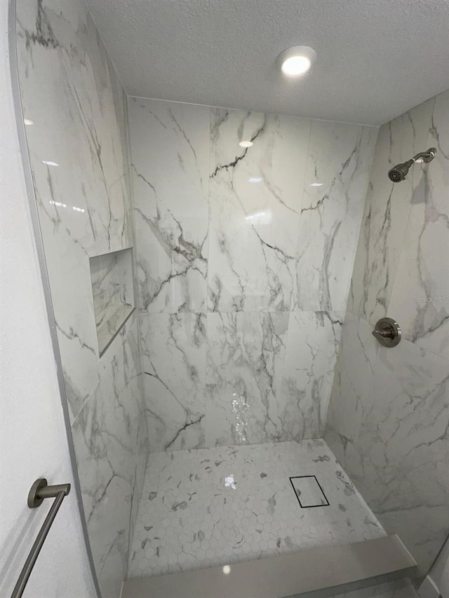 705 Wood Ln, Kissimmee, FL 34759 - bathroom with a marble finish shower and a textured ceiling