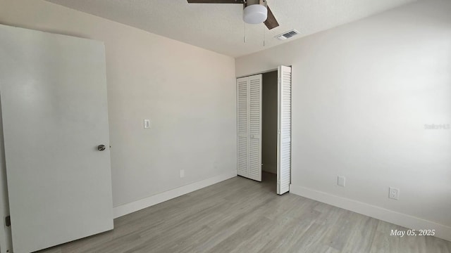 705 Wood Ln, Kissimmee, FL 34759 - unfurnished bedroom featuring a closet, visible vents, wood finished floors, and baseboards