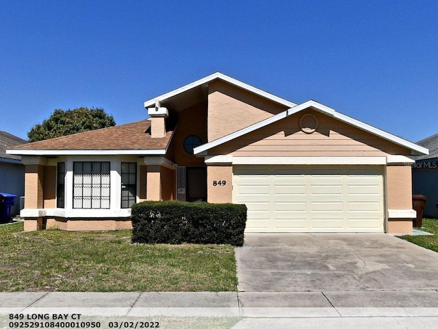 ranch-style house with a garage, stucco siding, driveway, and a front yard