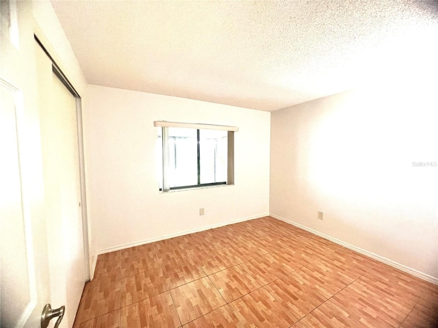 849 Long Bay Ct, Kissimmee, FL 34741 - unfurnished bedroom with a textured ceiling, a closet, light wood finished floors, and baseboards