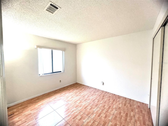 849 Long Bay Ct, Kissimmee, FL 34741 - unfurnished bedroom with a closet, a textured ceiling, and light tile patterned floors