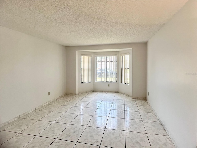 849 Long Bay Ct, Kissimmee, FL 34741 - empty room featuring a textured ceiling and light tile patterned floors