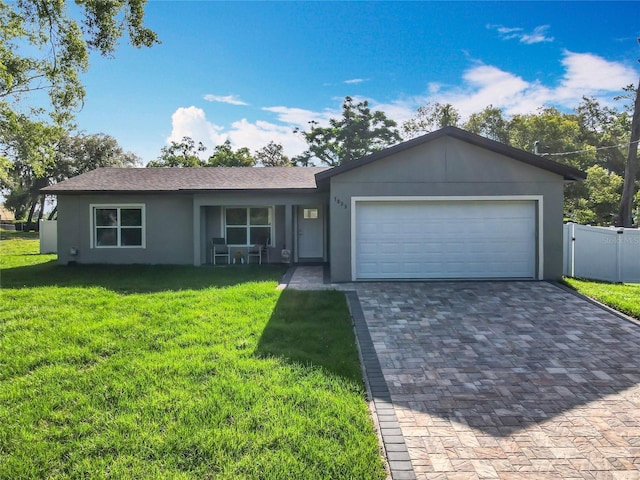 single story home featuring driveway, a garage, fence, a front lawn, and stucco siding