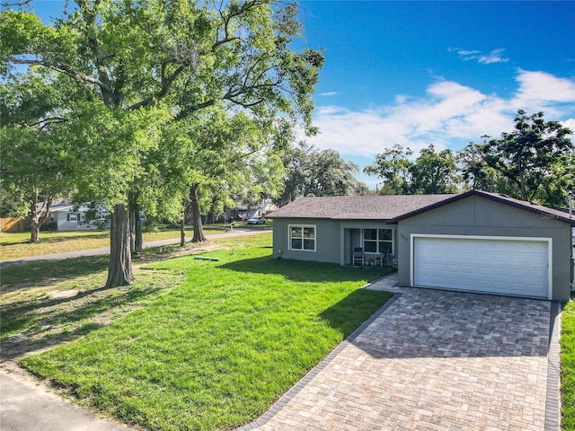 ranch-style house featuring a garage, a front lawn, stucco siding, and driveway