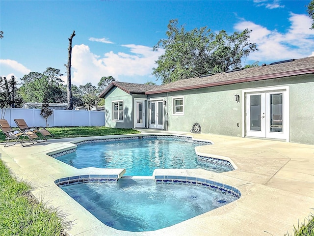 view of pool featuring french doors, fence, a pool with connected hot tub, and a patio area