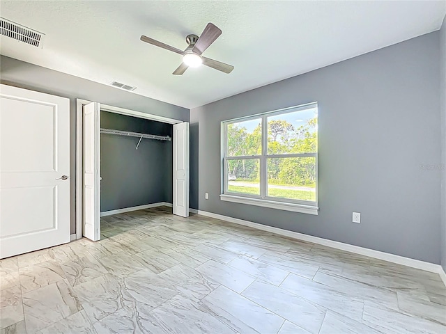 unfurnished bedroom featuring baseboards, a closet, marble finish floor, and visible vents