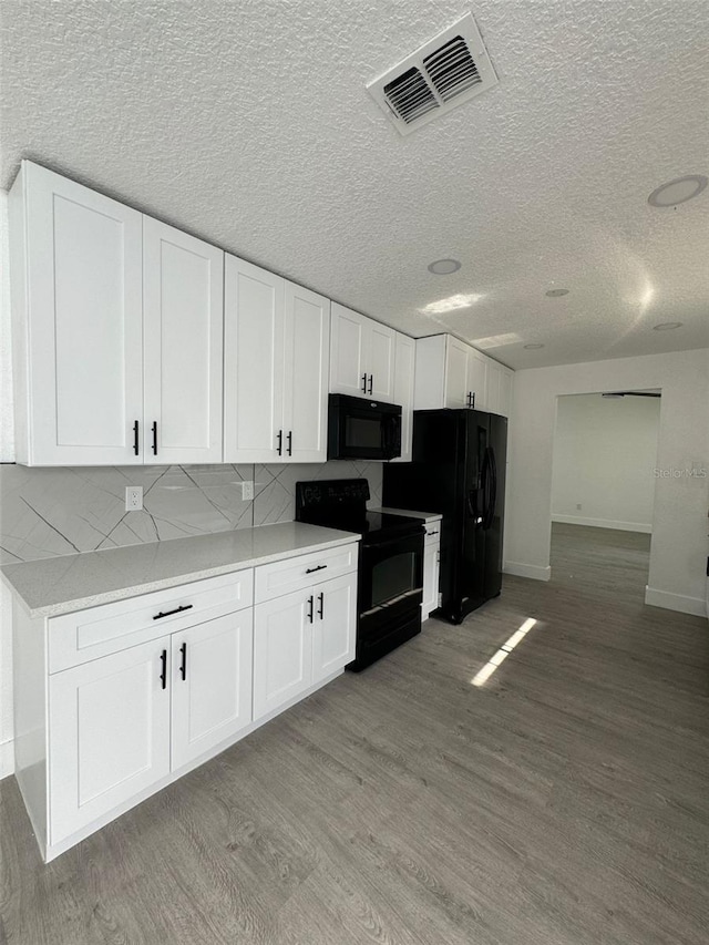 4385 NE 2nd Ct, Ocala, FL 34479 - kitchen featuring white cabinets, black appliances, light wood-style flooring, and visible vents