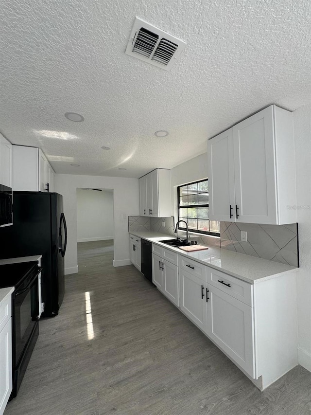4385 NE 2nd Ct, Ocala, FL 34479 - kitchen featuring white cabinets, a sink, light countertops, visible vents, and black appliances