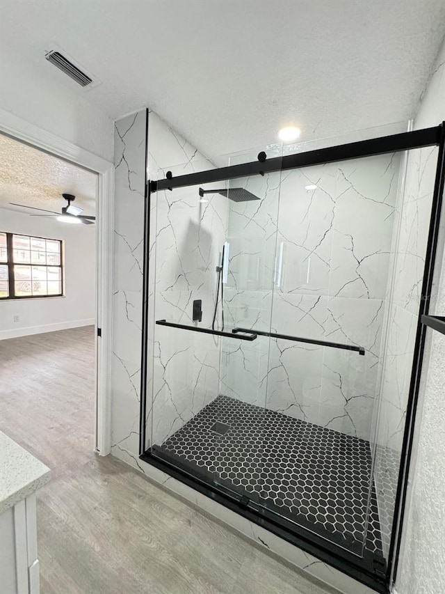 4385 NE 2nd Ct, Ocala, FL 34479 - bathroom with a marble finish shower, a textured ceiling, wood finished floors, and visible vents