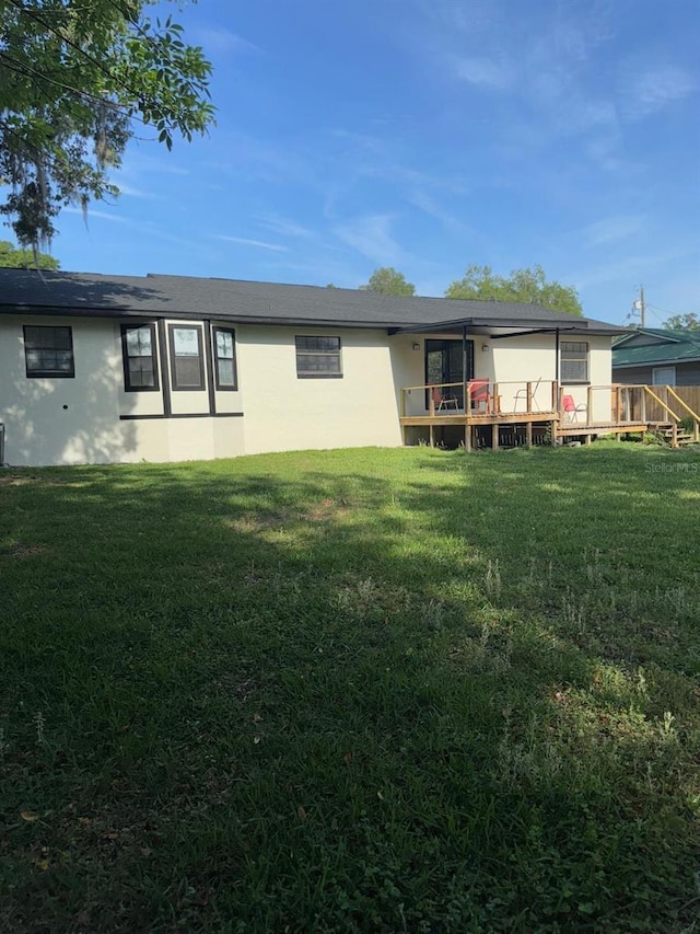 4385 NE 2nd Ct, Ocala, FL 34479 - back of property featuring a lawn, a wooden deck, and stucco siding