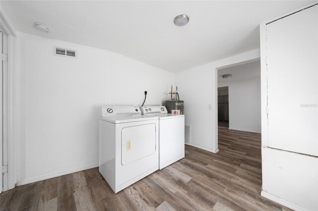 31 Cedar St, Haines City, FL 33844 - washroom with visible vents, laundry area, wood finished floors, independent washer and dryer, and water heater