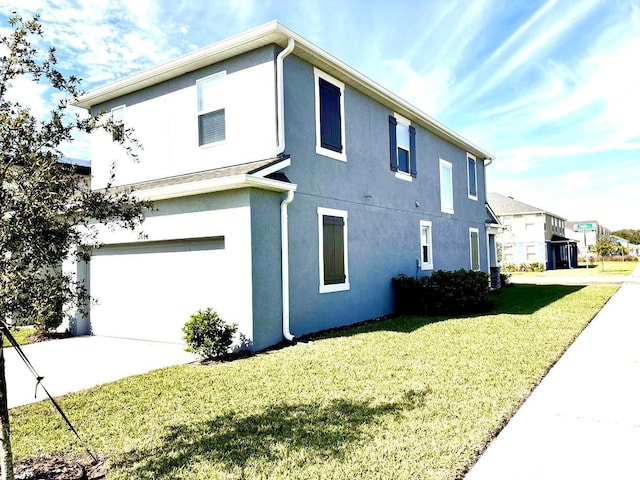 view of property exterior with a yard, an attached garage, and stucco siding