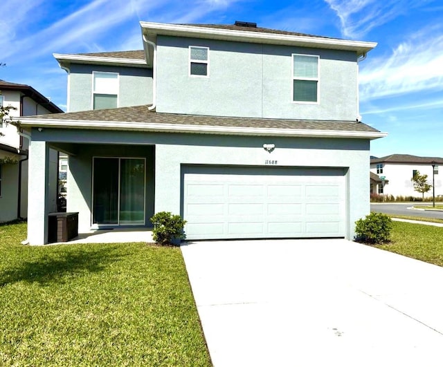 view of front of home featuring concrete driveway, a garage, a front yard, and stucco siding