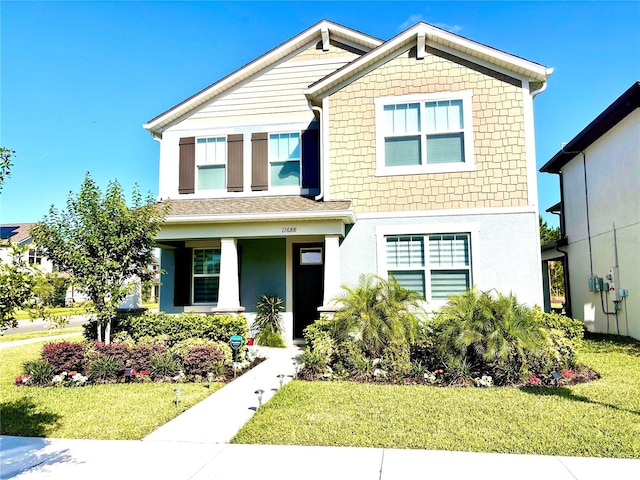 view of front of home with a porch, a front yard, and stucco siding